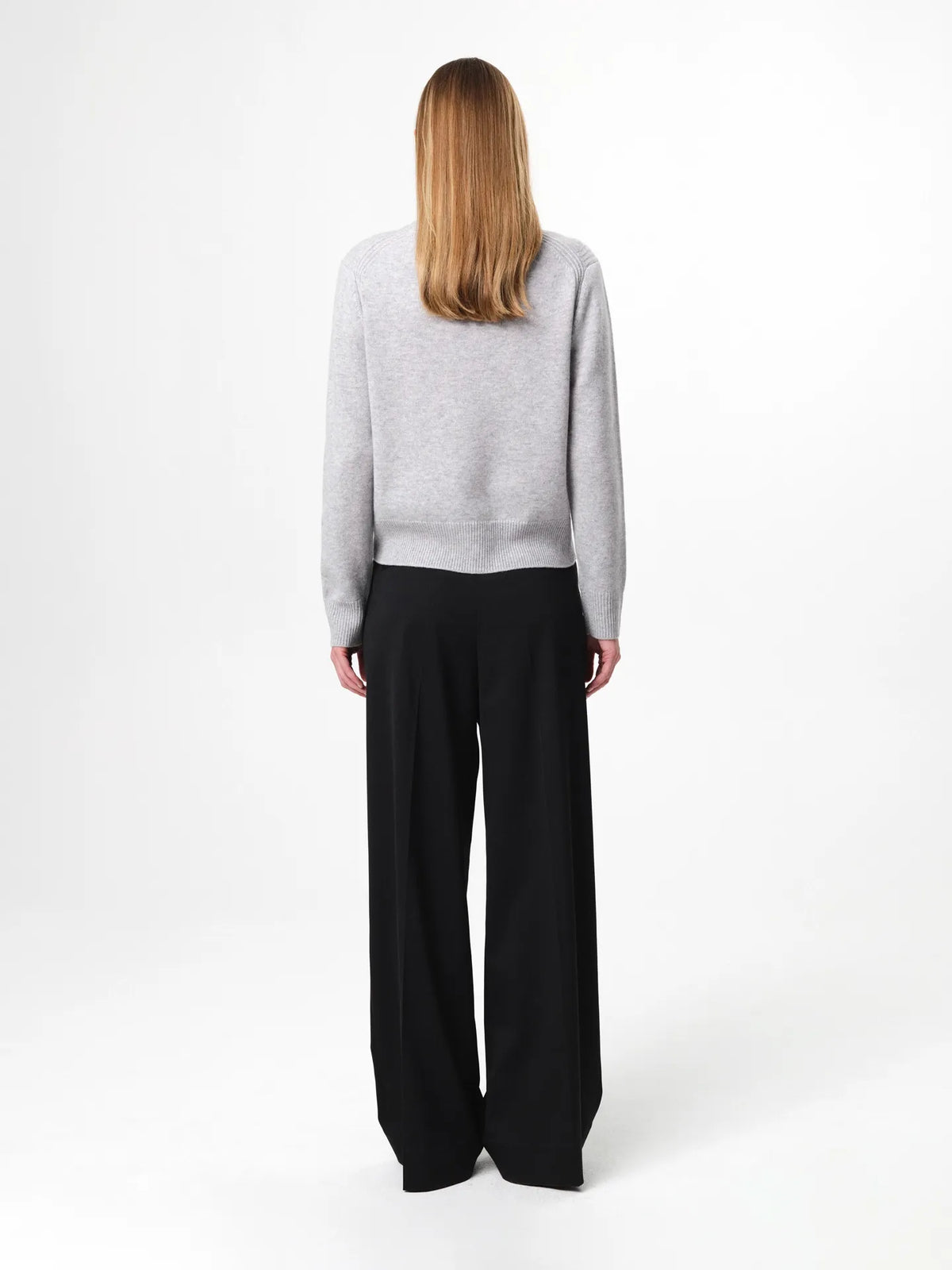 Model wearing the Alma Sweater in husky grey, a soft wool-cashmere crewneck with long sleeves and a clean, regular fit.