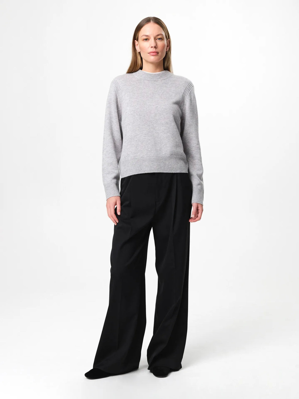 Model wearing the Alma Sweater in husky grey, a soft wool-cashmere crewneck with long sleeves and a clean, regular fit.