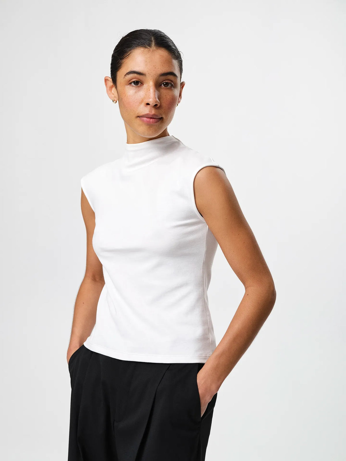 Julie Josephine Ariel Top White: fitted white top made from a 94% Italian pima cotton and 6% polyamide blend, crafted in a smooth stretchy jersey for a soft supportive feel, designed as a versatile wardrobe essential to wear on its own or as an easy layering base under shirts, blazers, and knitwear.