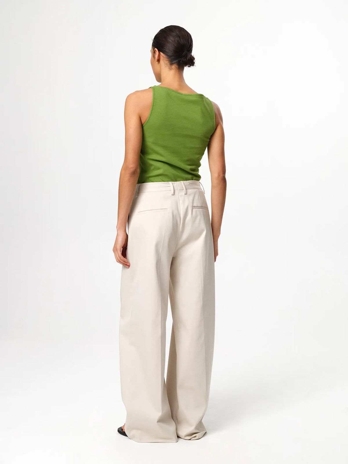 Julie Josephine Beatris Top Tulip Green: classic sleeveless top in tulip green made from a soft 94% Italian pima cotton and 6% polyamide blend, designed with a subtle raised boat neck that elevates the clean minimal silhouette, styled to tuck into wide leg trousers or shorts for an effortless polished look, shown on a 176 cm model wearing size S.
