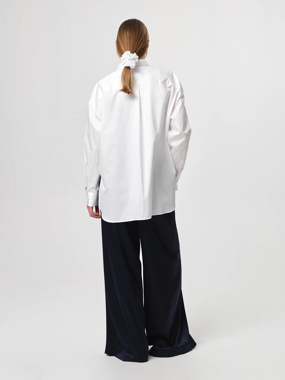 Edwina Shirt in white, cut from crisp cotton poplin with an oversized tailored silhouette, sharp collar, dropped shoulders and a gently curved hem.