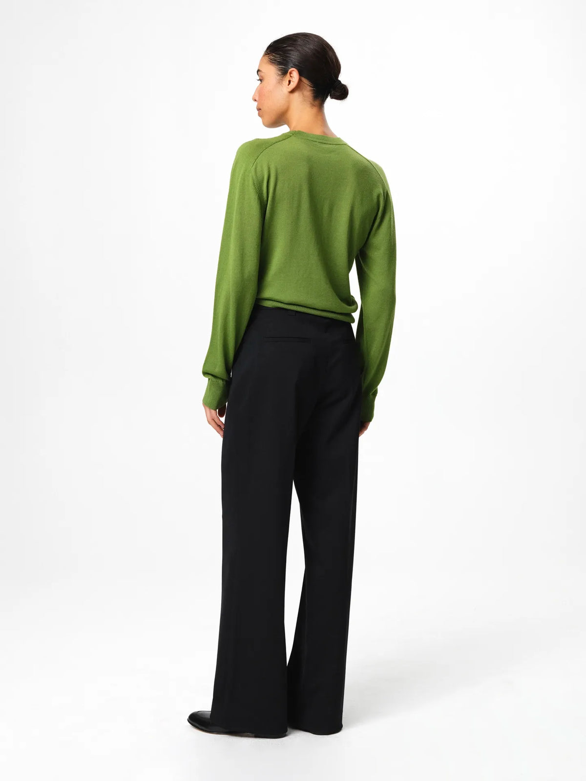 Julie Josephine Hanne Sweater Tulip Green: modern wardrobe essential classic round neck sweater knitted from 100% merino wool for lightweight warmth and a soft luxurious feel, shown in tulip green and styled to wear on its own or layered with a t shirt underneath, note that it fits small so taking one size up gives a more relaxed fit.