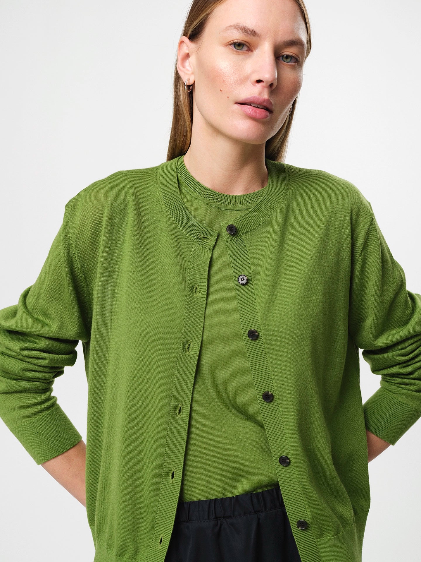 Julie Josephine Tanja Wool Top Tulip Green: refined sleeveless knit top made from 100% merino wool with a soft lightweight feel against the skin, clean regular fit with a classic crew neckline, designed for effortless layering worn on its own or under knits, blazers, and jackets, also styled over a shirt for a polished look, true to size with a relaxed silhouette and shown on a 173 cm model wearing size S.