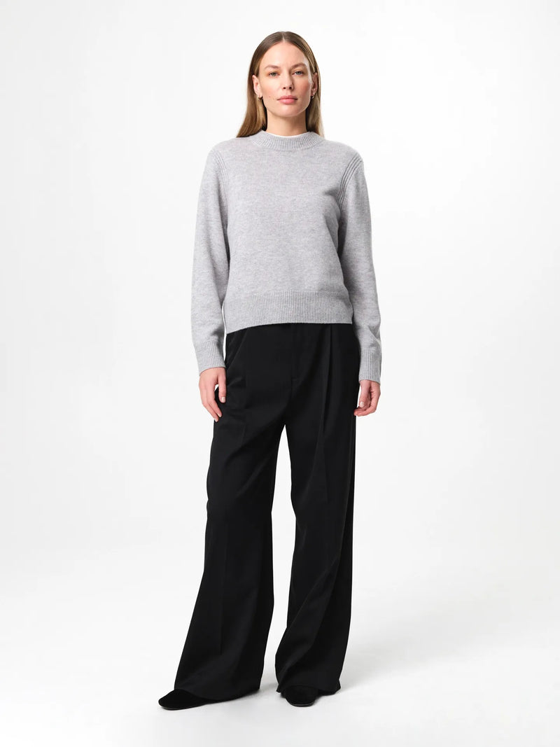 Model wearing the Alma Sweater in husky grey, a soft wool-cashmere crewneck with long sleeves and a clean, regular fit.