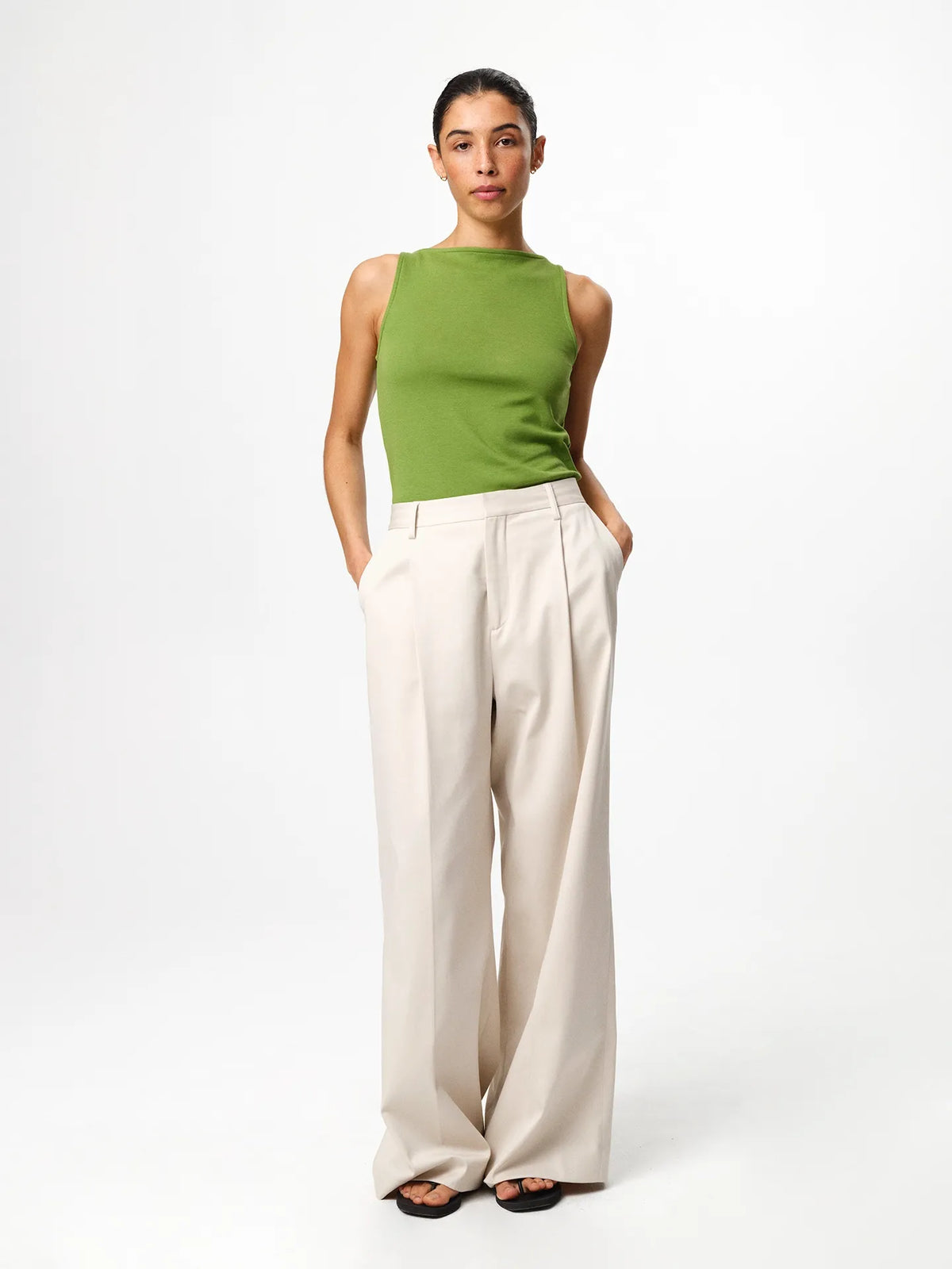 Julie Josephine Beatris Top Tulip Green: classic sleeveless top in tulip green made from a soft 94% Italian pima cotton and 6% polyamide blend, designed with a subtle raised boat neck that elevates the clean minimal silhouette, styled to tuck into wide leg trousers or shorts for an effortless polished look, shown on a 176 cm model wearing size S.