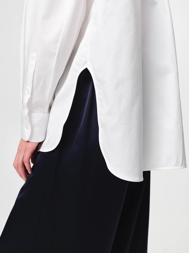 Edwina Shirt in white, cut from crisp cotton poplin with an oversized tailored silhouette, sharp collar, dropped shoulders and a gently curved hem.