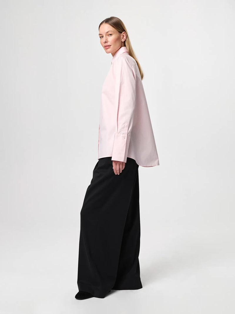 Julie Josephine Julie Shirt Peony Pink: iconic bestselling cotton twill shirt in peony pink made from crisp 100% cotton, tailored with a fitted shoulder and clean straight body for a polished silhouette, finished with elongated statement cuffs and a modern curved hem, designed to wear untucked or layered under a favorite knit with the cuffs showing, crafted in Portugal as a timeless wardrobe staple made to be worn, loved, and kept for years.