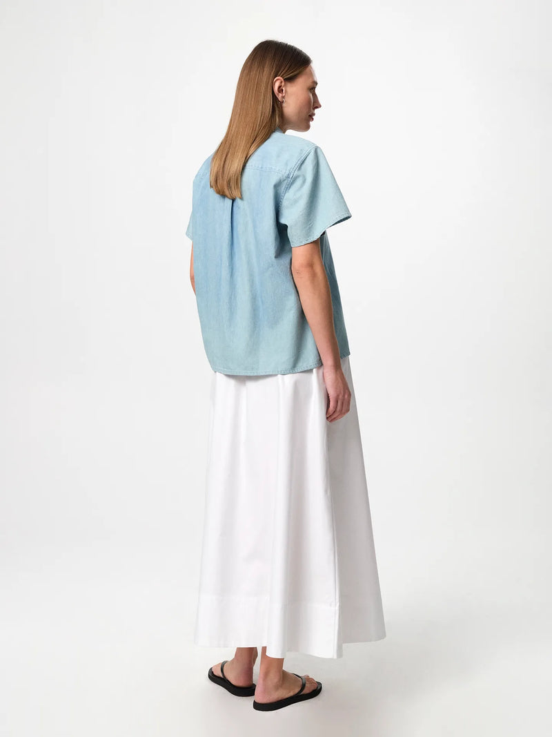 Julie Josephine June Denim Shirt Light Denim: light denim shirt in a pale blue wash designed with a clean classic silhouette for effortless everyday styling, a versatile wardrobe staple to wear buttoned up on its own or layered open over a tee, easy to dress up with tailored pieces or keep casual with denim.