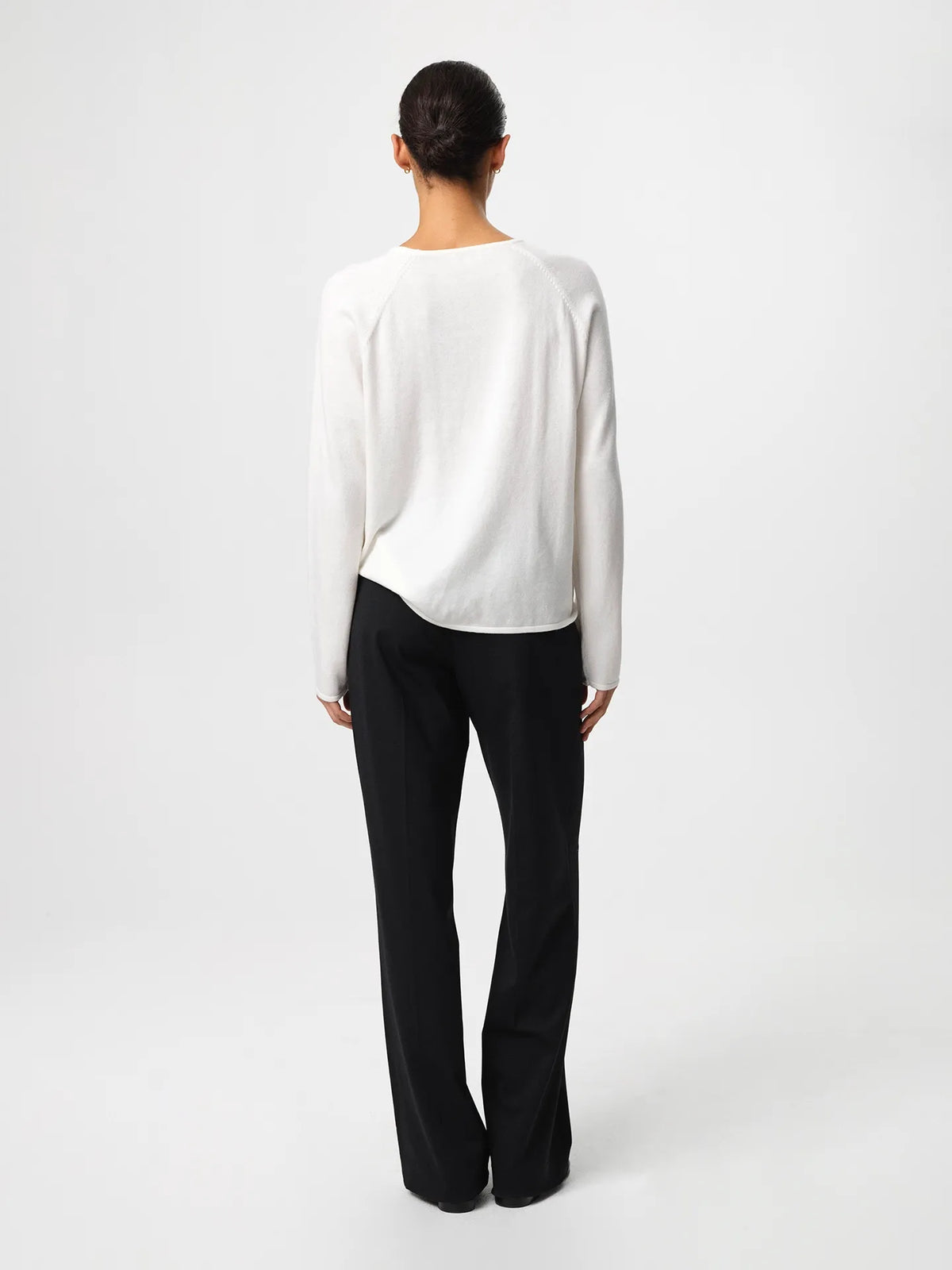 Julie Josephine Kate Roundneck Sweater Off White: product image of a soft, lightweight knit sweater in an off white shade, made from a wool and cotton blend that combines warmth with breathability, designed with a relaxed silhouette, long sleeves, subtle dropped shoulders, and a clean neckline, styled for easy everyday layering over a T shirt or worn on its own with tailored trousers or denim.
