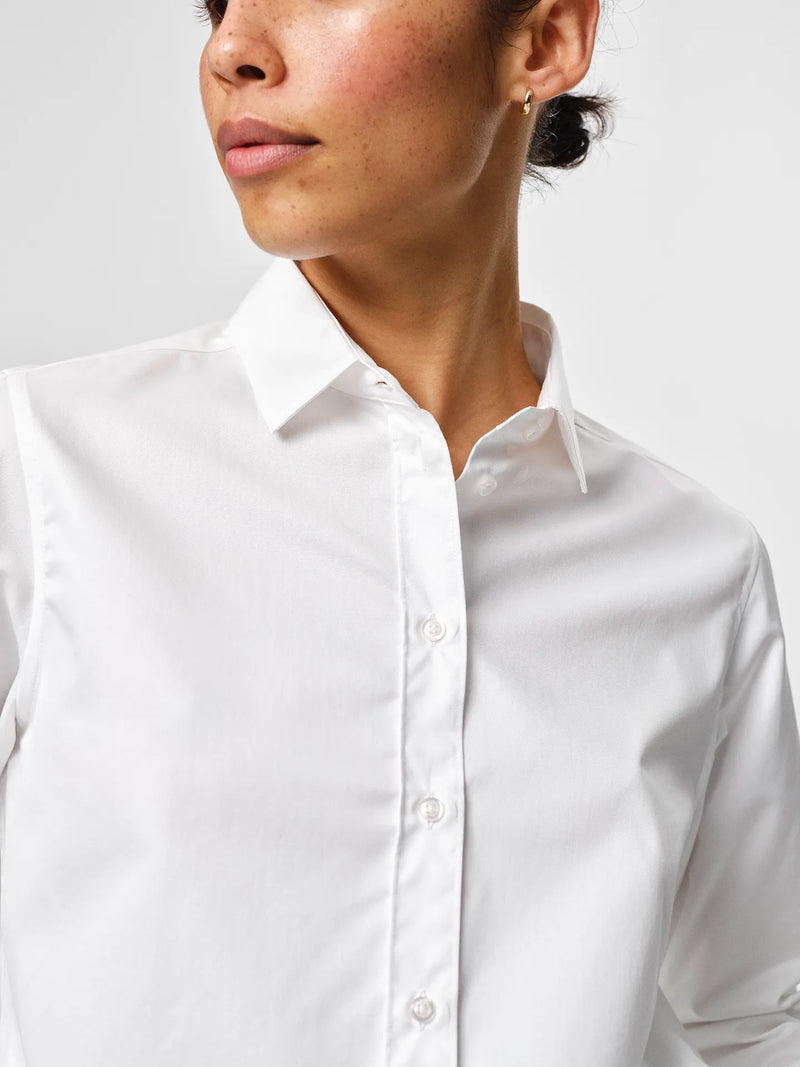Liv Shirt in white, crafted from crisp cotton twill with a fitted shoulder, slight volume in the back and a sharp collar.