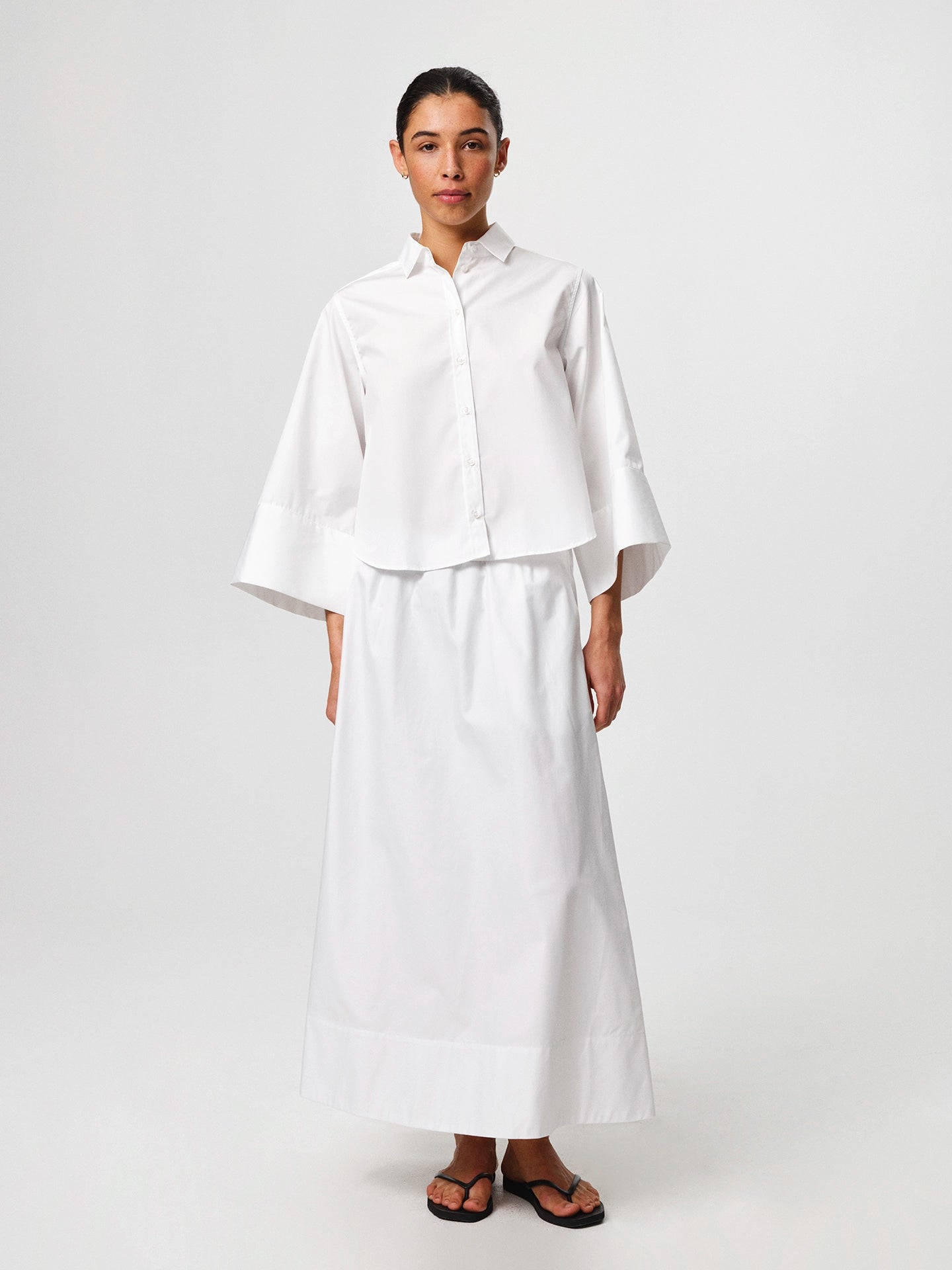 Julie Josephine Anja Shirt White: crisp white shirt made from 100% cotton with a clean classic silhouette, designed as a versatile wardrobe staple that works polished on its own or layered under knitwear and outerwear for effortless everyday styling.